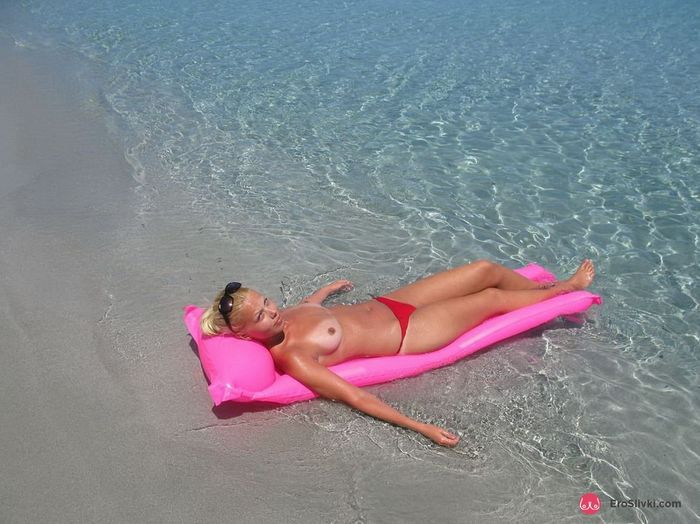 Русская светлая порно звезда на пляже лежит под солнцем топлесс